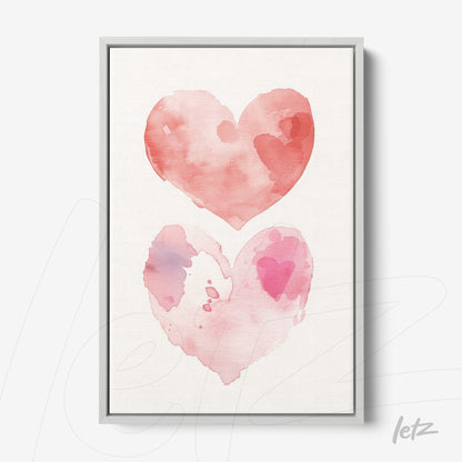 framed wall art featuring watercolor hearts in shades of pink with light gray frame