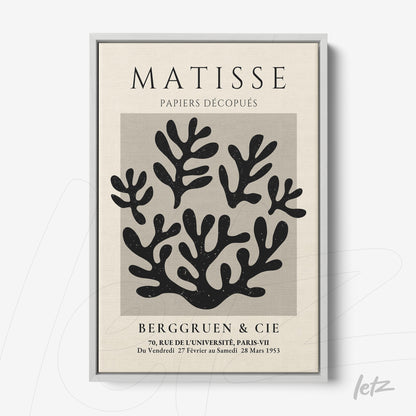 framed wall art featuring paper cut-out design in black on light background with silver frame and bold title