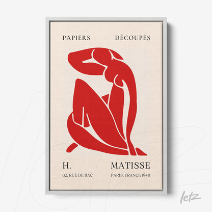 framed art featuring a cut-out red figure on a light background with a silver frame