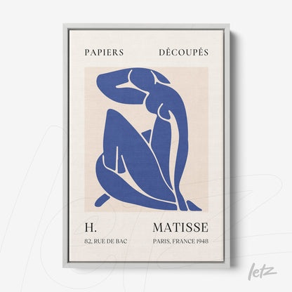 framed wall art featuring a blue cut-out figure against a neutral background with a light gray frame
