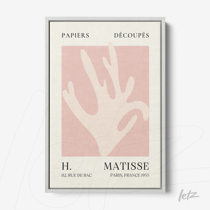 framed wall art featuring an abstract hand design on a light pink background with silver frame