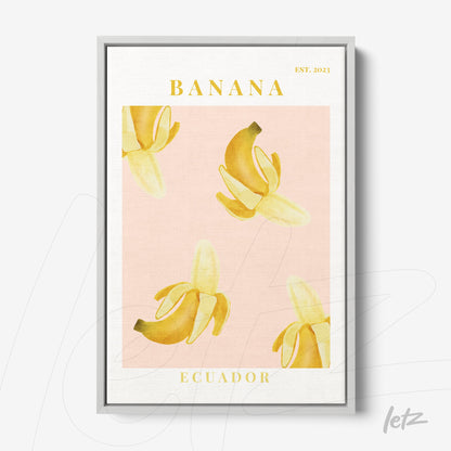 framed wall art featuring yellow banana illustrations on pink background with silver frame and stylized yellow text