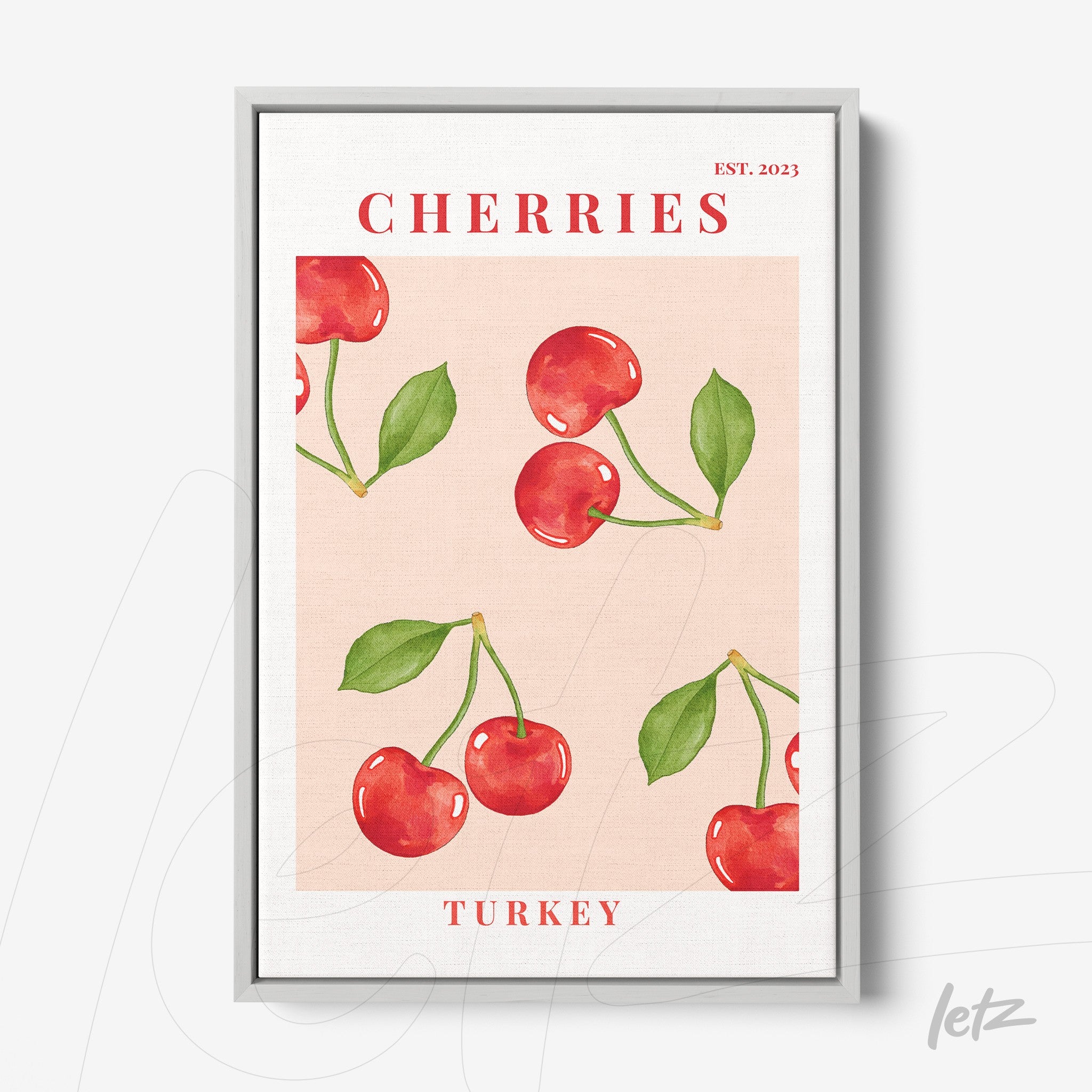 framed art print featuring red cherries on pink background with silver frame and bold text