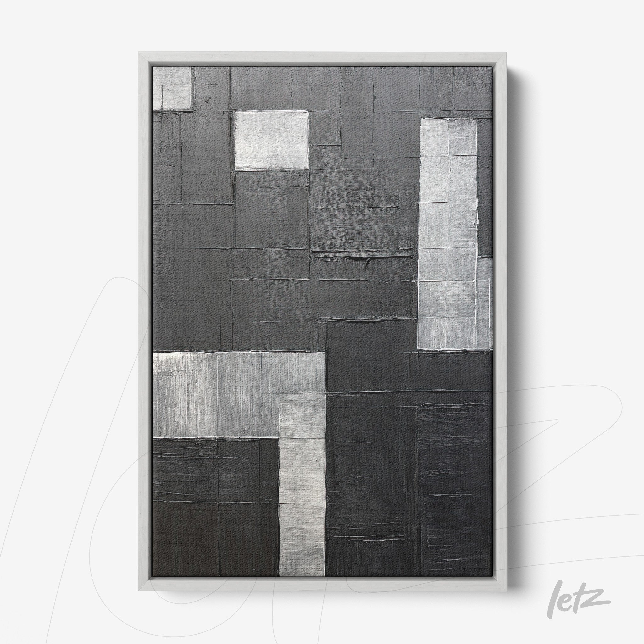abstract wall art in shades of black and gray with varied textures in white frame