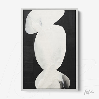 abstract wall art featuring white shapes on a black background in a light frame