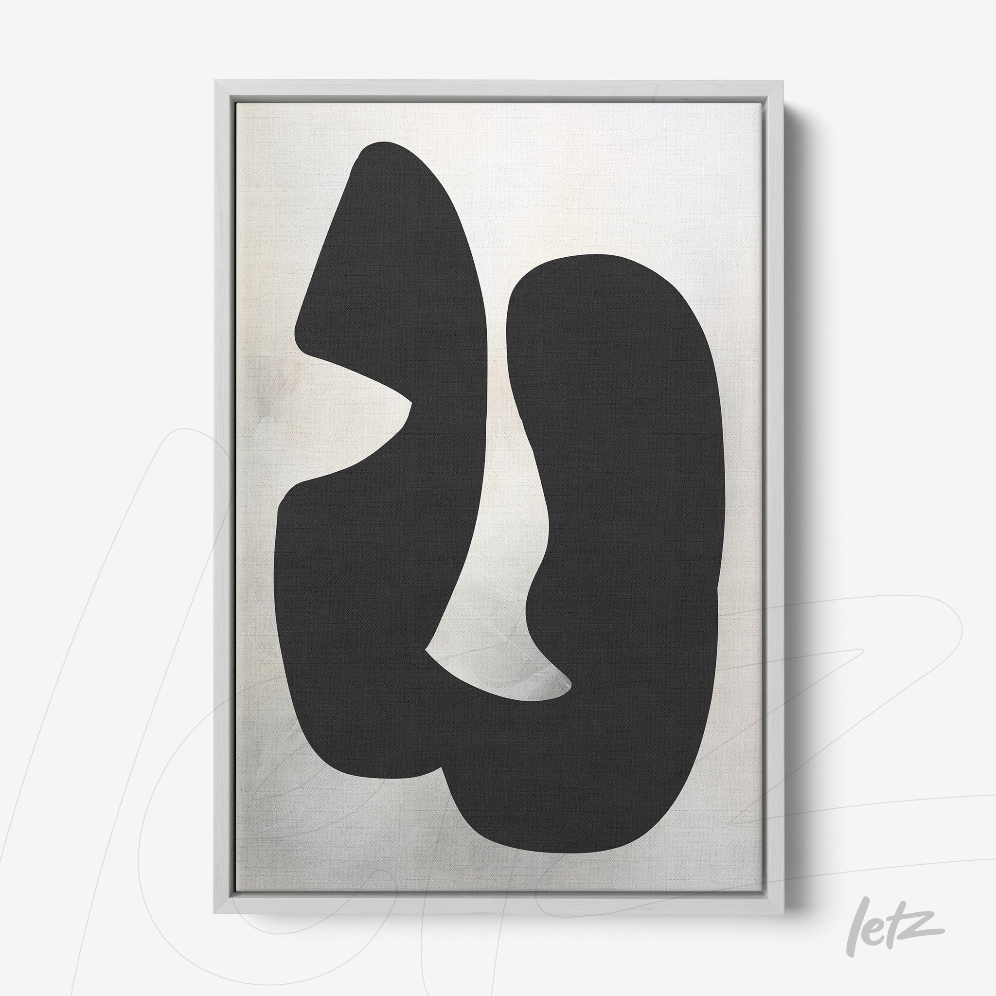 abstract wall art with black shapes on light background, framed in gray