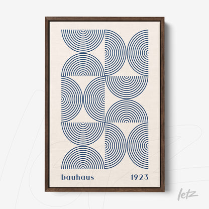 framed art with geometric pattern of concentric blue arcs and text bauhaus 1923 in dark wooden frame