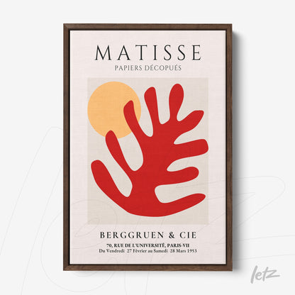 framed wall art featuring abstract shapes in red and orange tones with a dark wood frame and light background