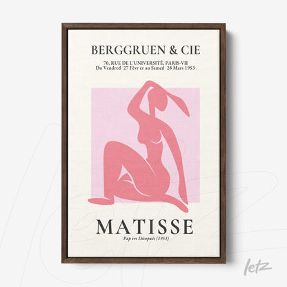 framed wall art featuring modern design in shades of pink and red depicting a female silhouette with dark wood frame