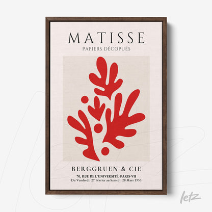 framed modern art print featuring red cutouts on a light background with dark wood frame