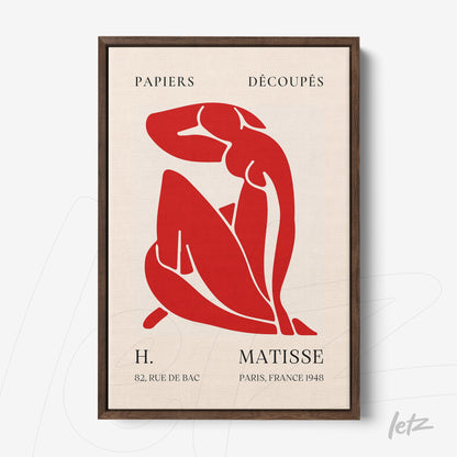 framed wall art featuring abstract red figure of a woman with dark wooden frame and light background