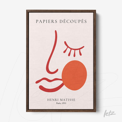 framed abstract art of a face in red and terracotta with the title PAPIERS DÉCOUPÉS and dark wood frame