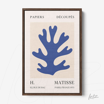 framed modern art print in blue and beige featuring a cutout design of coral shape with dark wood frame