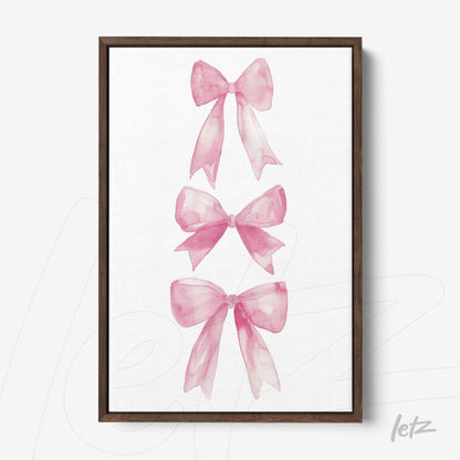 framed watercolor art featuring pink bows with a dark wood frame