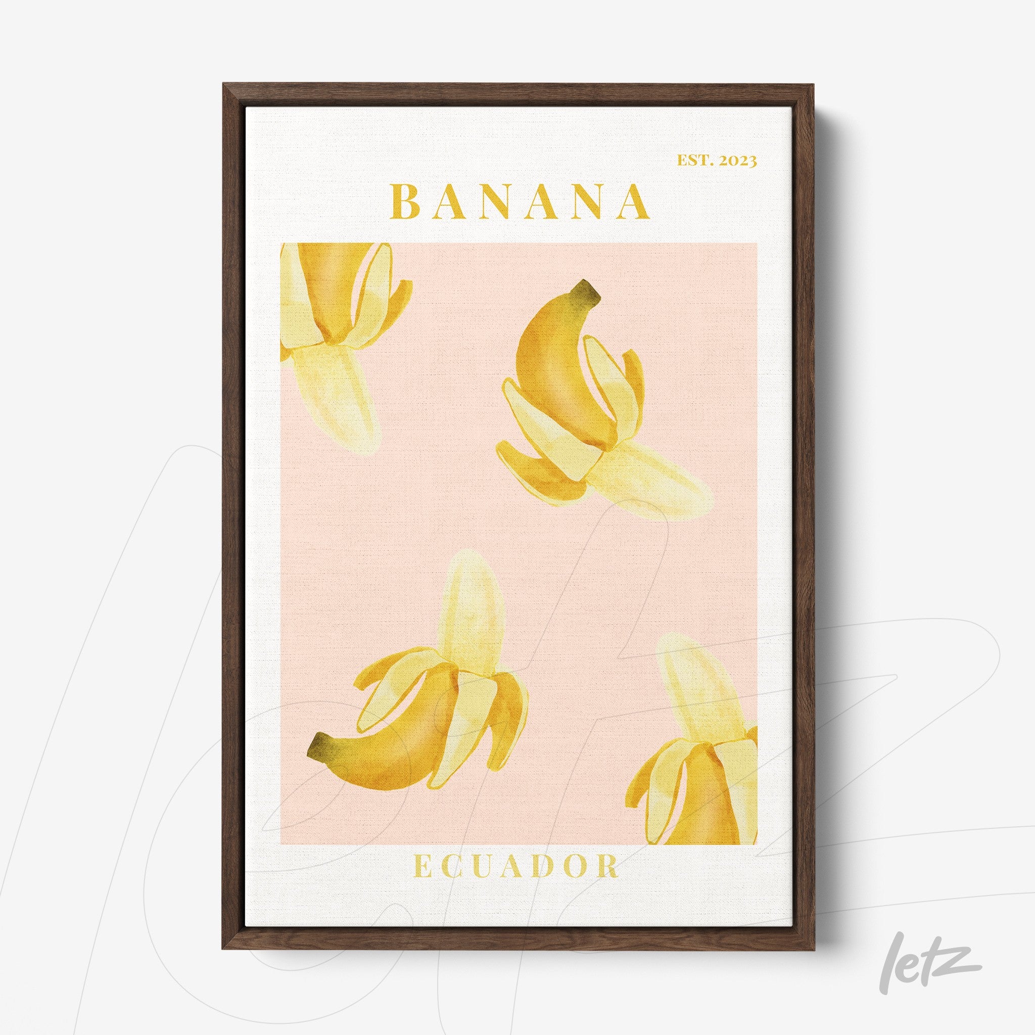framed wall art featuring banana illustrations on a pink background with a dark wood frame