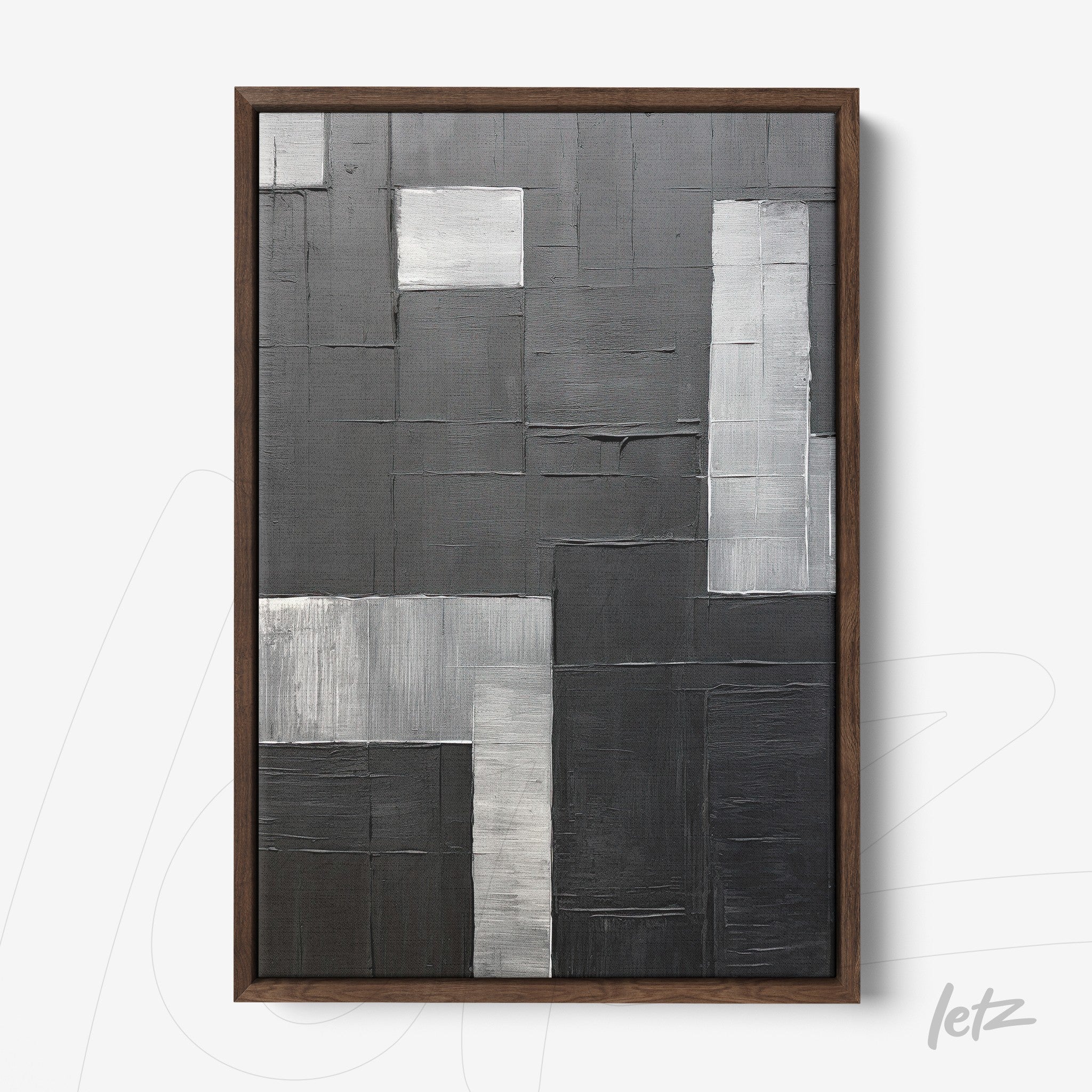 abstract wall art in shades of gray with varied textures framed in dark wood