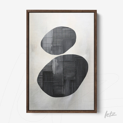 framed abstract art featuring black and gray shapes with a dark wooden frame