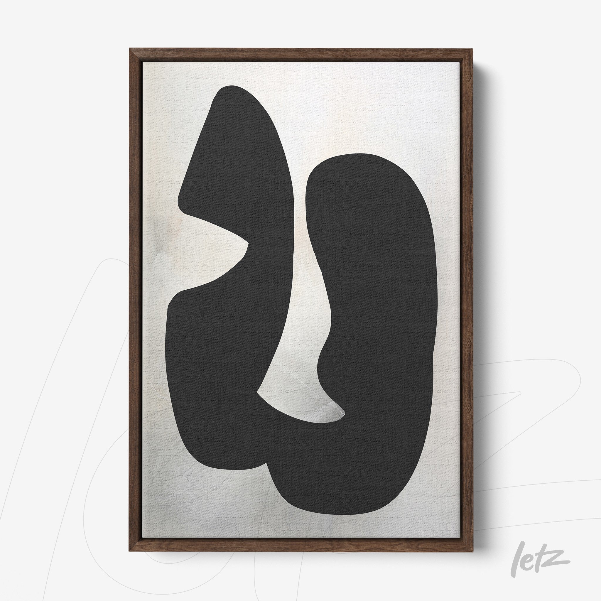 abstract wall art featuring black shapes on light background in dark wooden frame