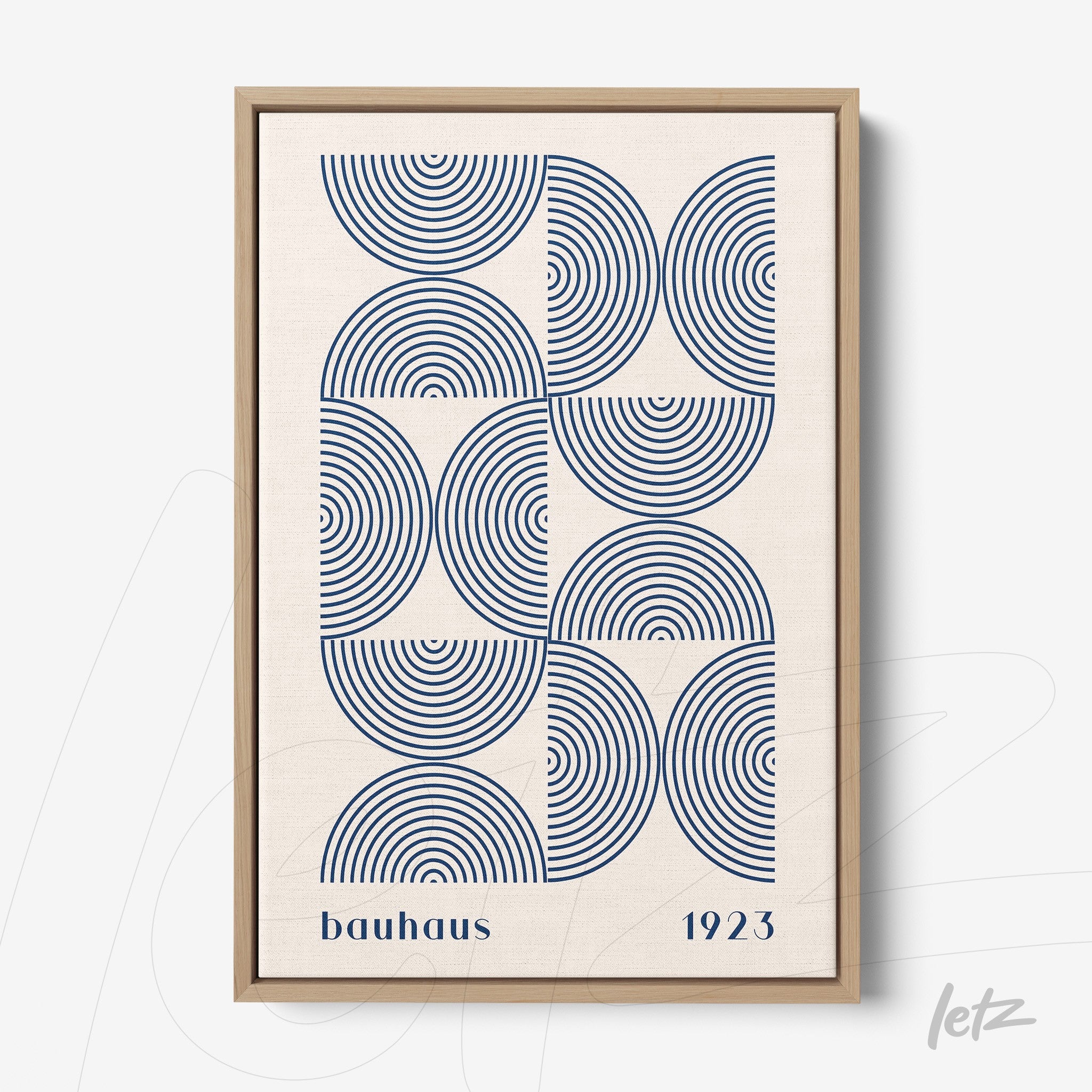 canvas print with geometric art in blue tones featuring concentric circles and bauhaus typography, framed in light wood