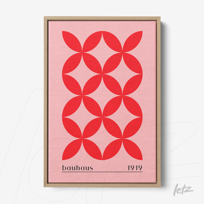 poster print with red geometric design on a pink background, light wood frame