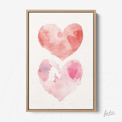 framed wall art featuring watercolor illustration of two interconnected hearts in shades of pink with light wood frame