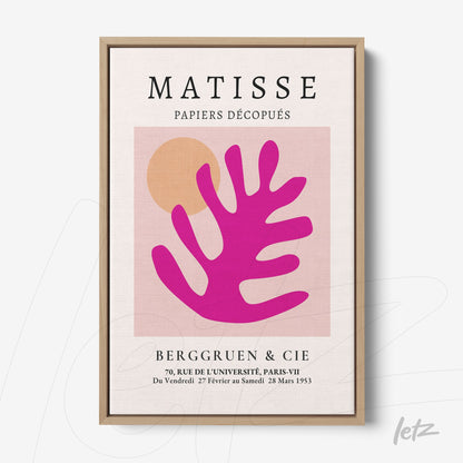 framed modern art featuring a stylized leaf in shades of pink and orange with a light wood frame