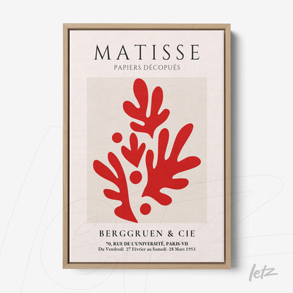 framed artwork featuring red cut-out shapes inspired by Matisse with light wood frame