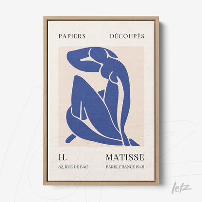 framed modern art piece featuring a stylized blue figure on a neutral background with a light wood frame