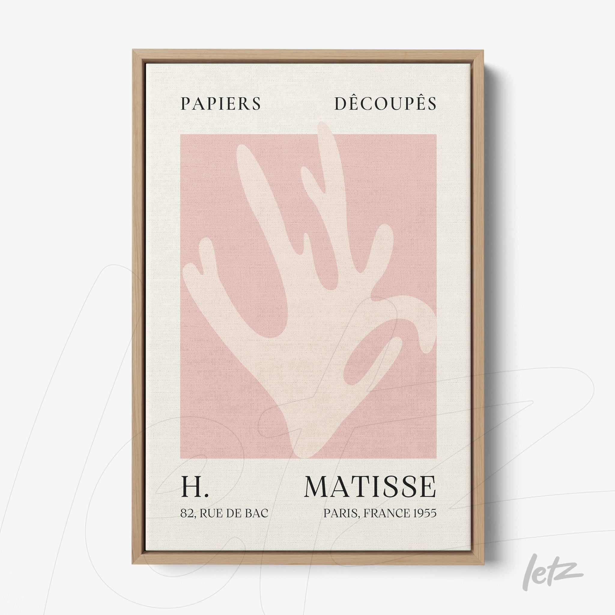 framed modern art of a stylized hand on light pink background with light wood frame