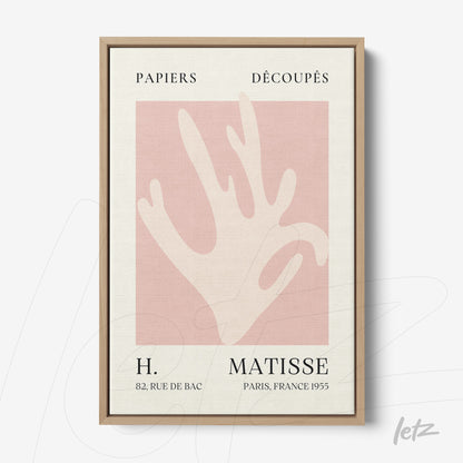 framed modern art of a stylized hand on light pink background with light wood frame