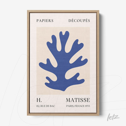 framed abstract art of blue coral on a light background with vintage text details and a light wooden frame