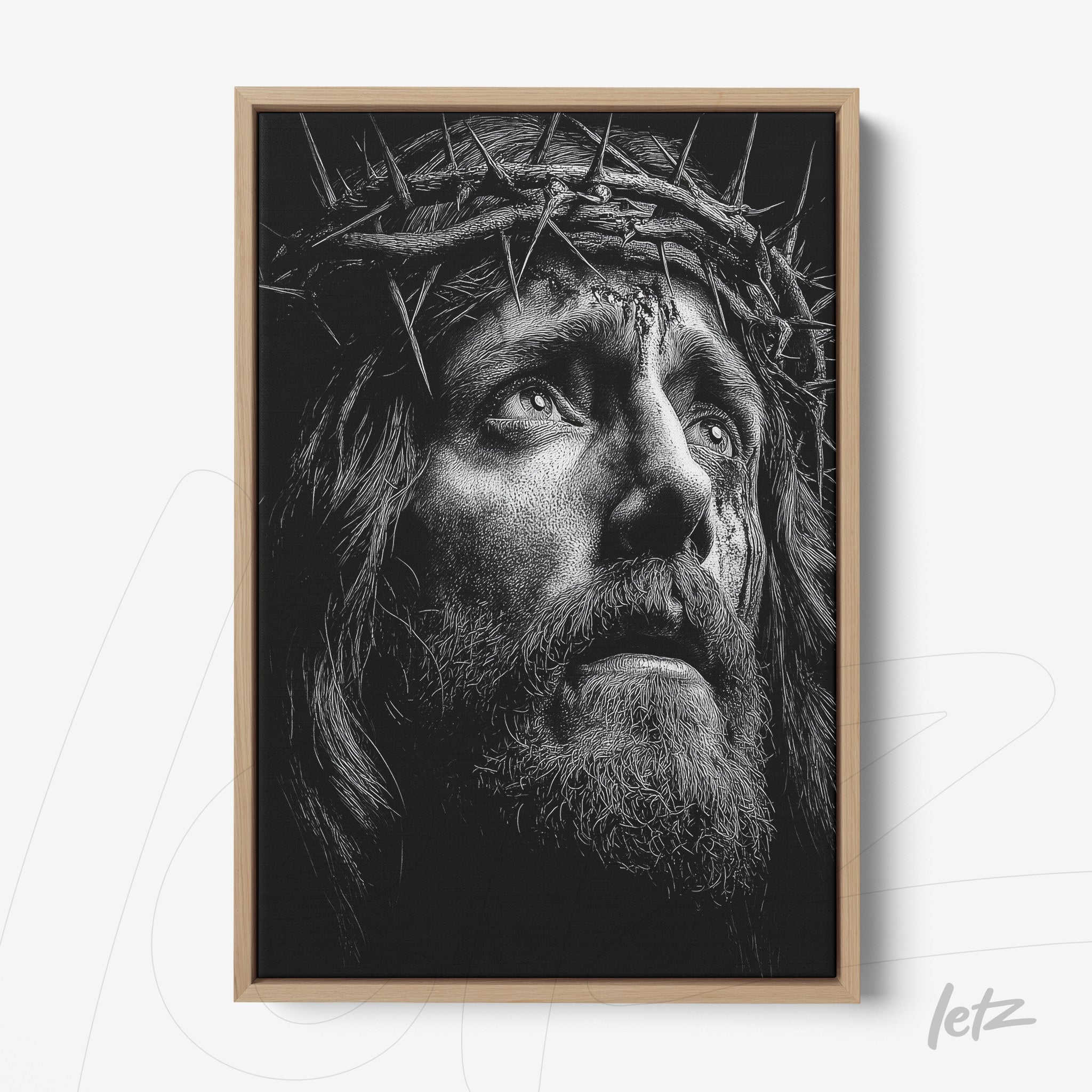framed artwork depicting the face of Christ wearing a crown of thorns with light wood frame