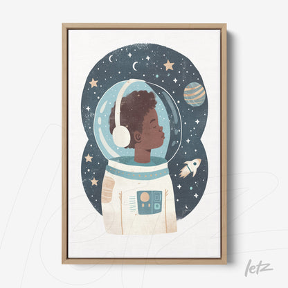 framed artwork of a young astronaut boy in a space suit with a starry background and planet, light wood frame