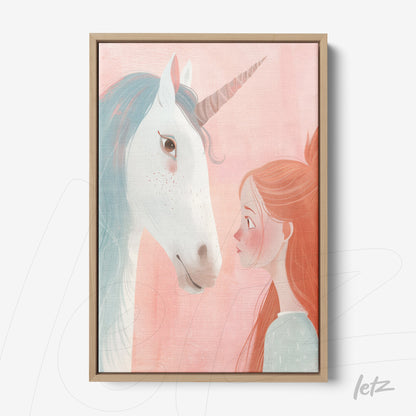 framed wall art featuring a girl gazing at a unicorn with a soft pink background and light wood frame