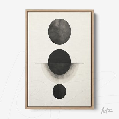 abstract wall art featuring black and white circles of varying sizes in light wood frame