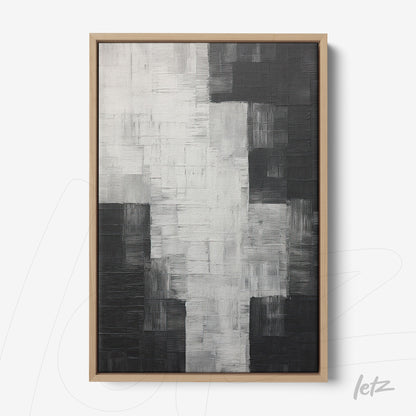 canvas print featuring abstract art in shades of black, white, and gray with a light wood frame