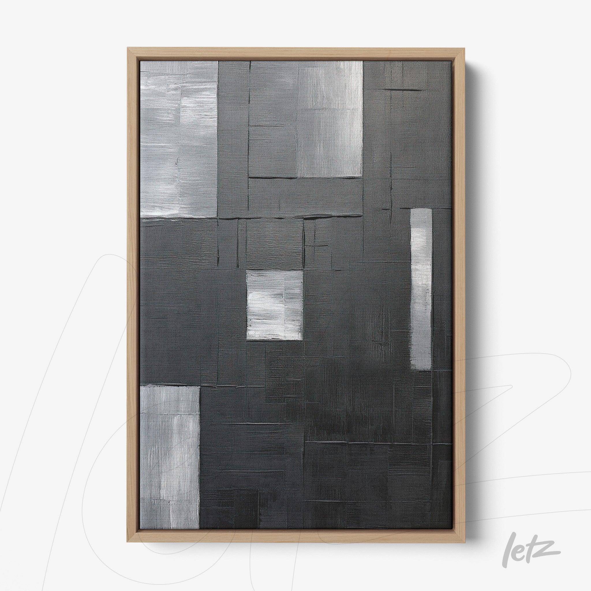 abstract wall art in black and gray with textured rectangles on a uniform background, framed in light wood