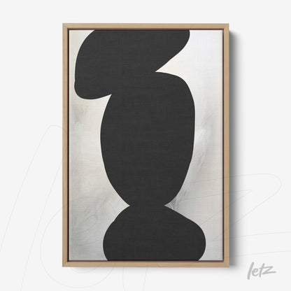 framed abstract art piece featuring organic shapes in black on a light background with a light wood frame