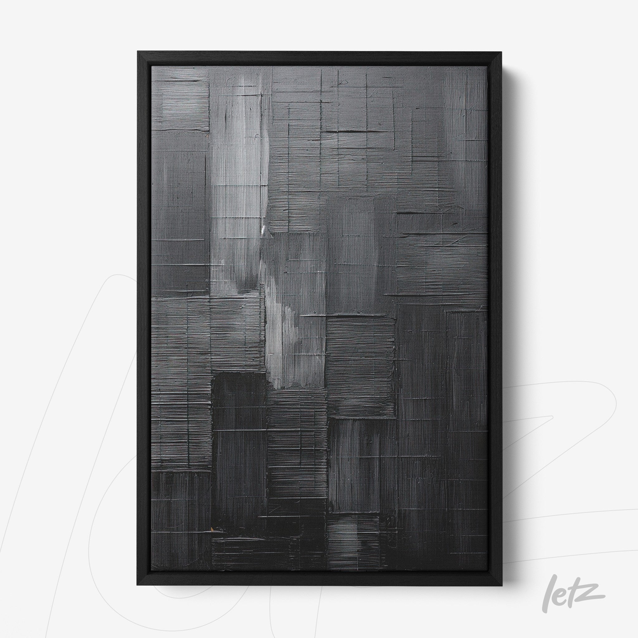 abstract wall art in shades of black and gray within a black frame