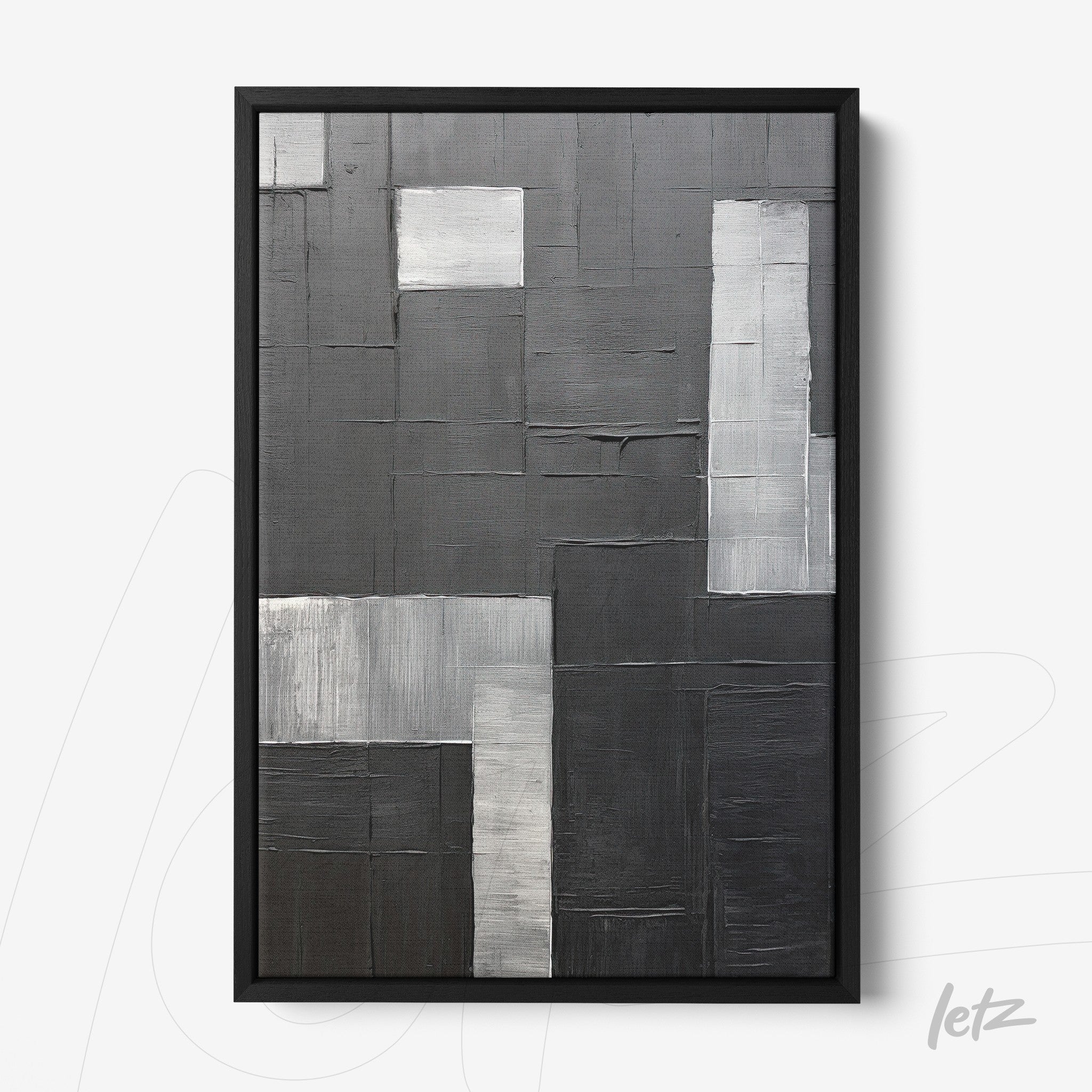 abstract wall art featuring textures in black and gray tones, framed in black