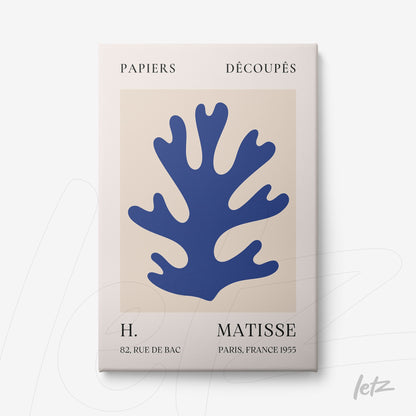 framed wall art featuring a paper cut design of a blue coral against a beige background in a minimalist style