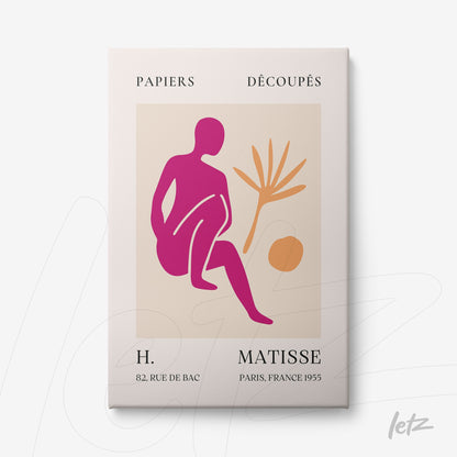 framed artwork featuring a graphic design of a seated human figure in pink tones, accompanied by a palm leaf and a circle, with a light frame