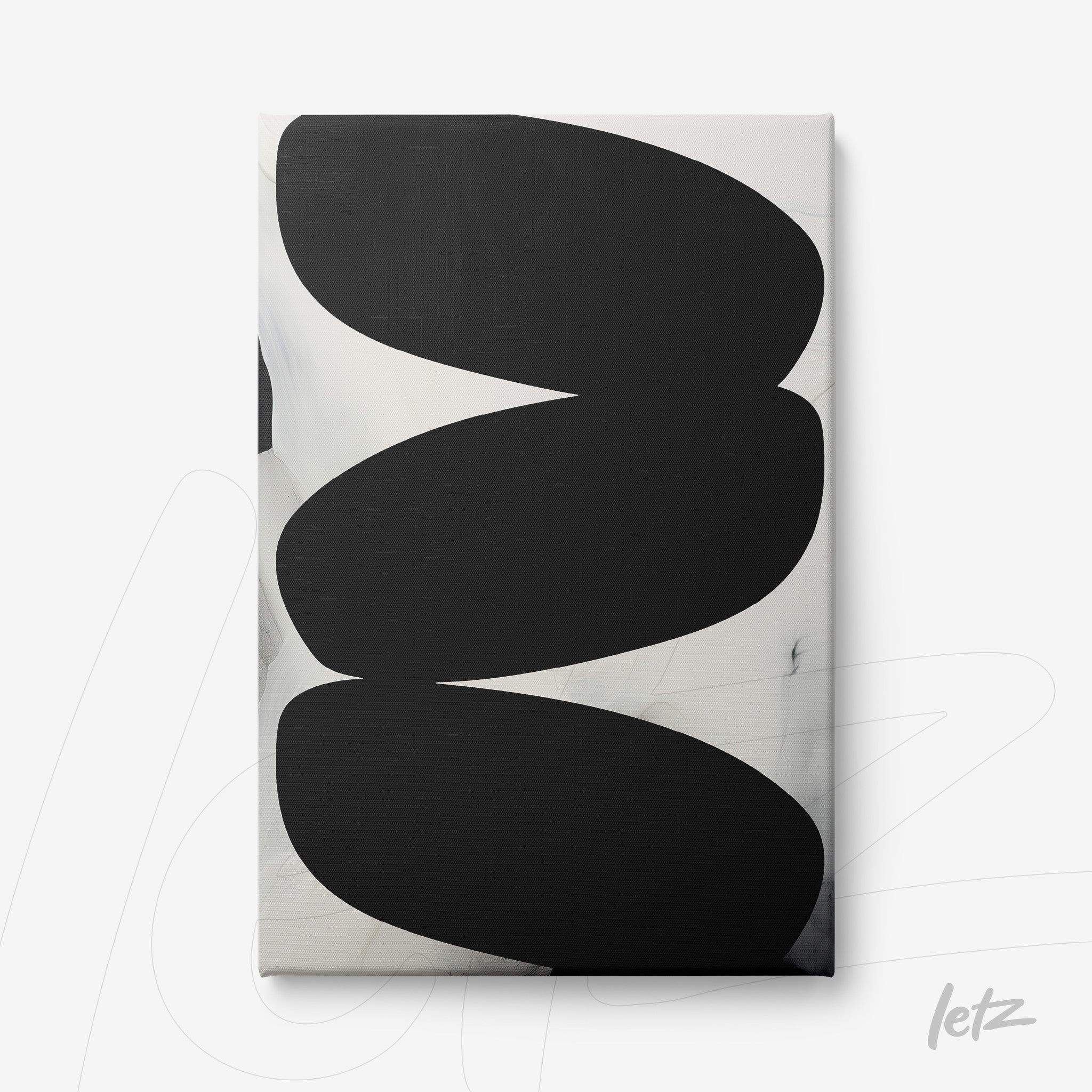 abstract wall art with large black oval shapes on a light background