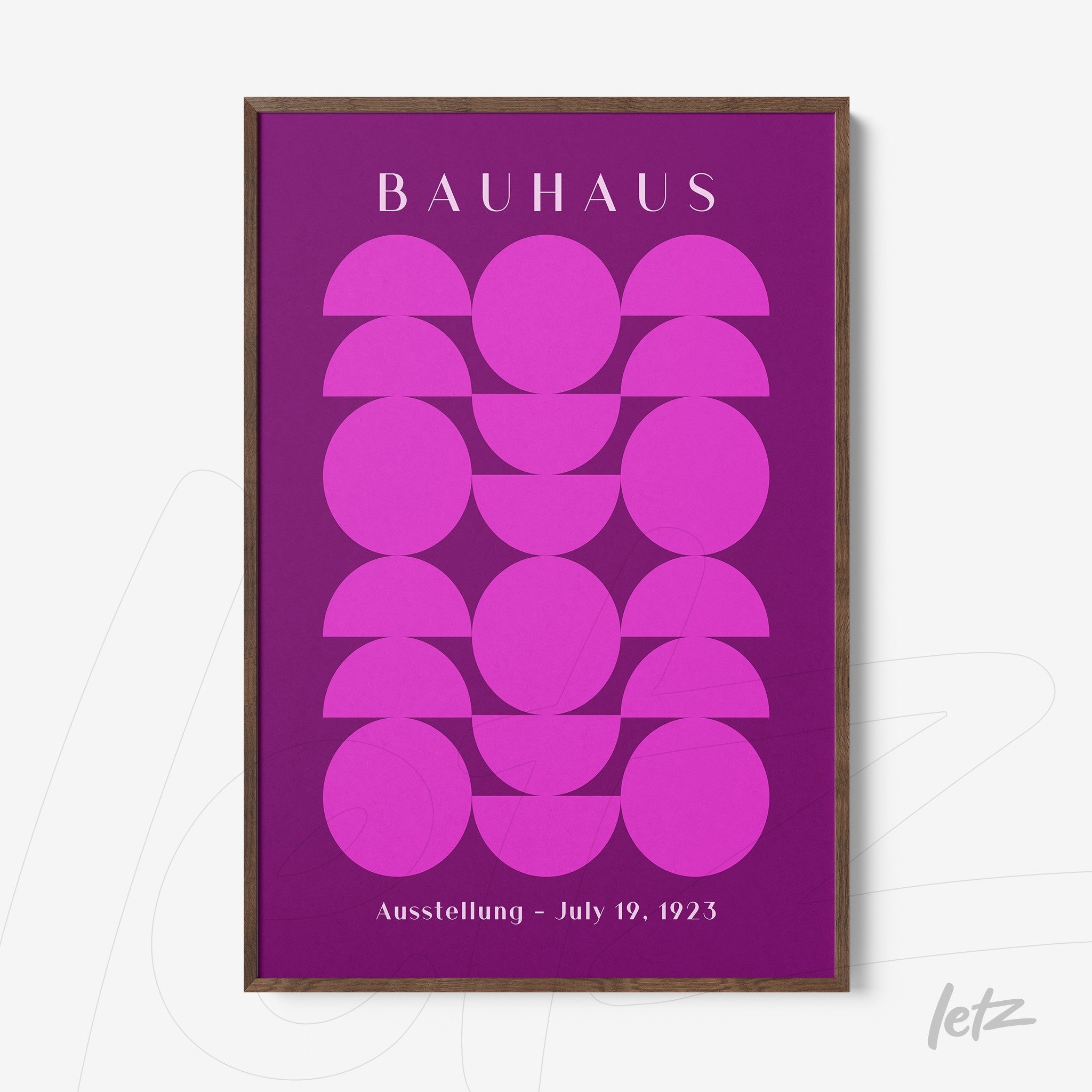 poster featuring geometric art in shades of pink and purple, with a dark wood frame