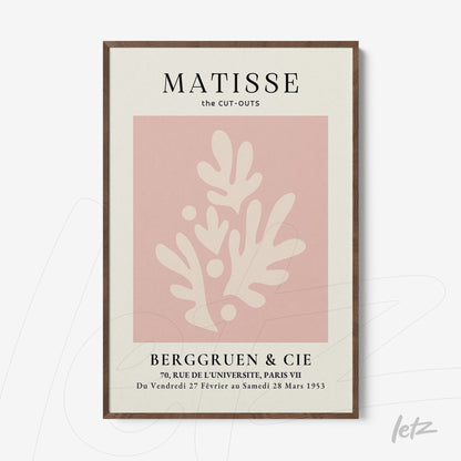 framed modern art featuring abstract shapes in pink against a light background with dark wood frame