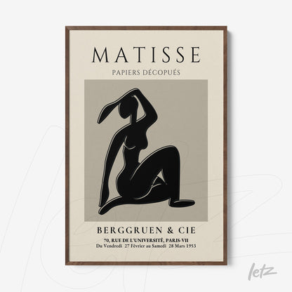decorative wall art featuring paper cutout of a female figure in black background, dark wood frame with minimalist design