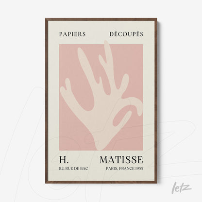 framed wall art featuring a stylized hand on light pink background with dark wood frame
