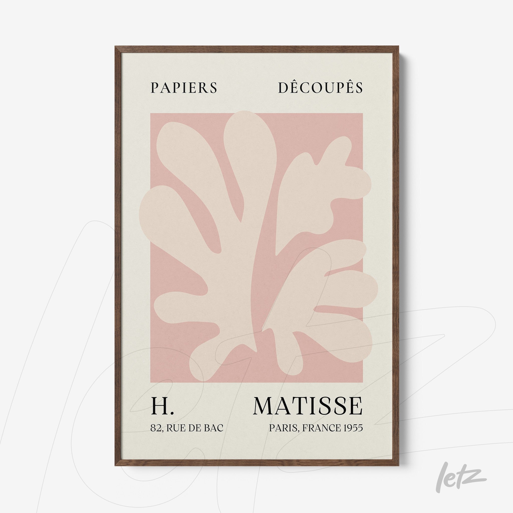 framed wall art featuring abstract leaf shapes in shades of pink and cream with dark wood frame