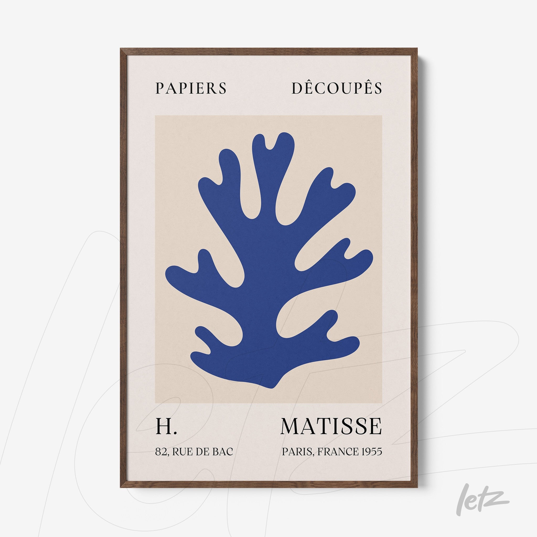 framed modern art featuring blue coral cutouts on light background with dark wood frame