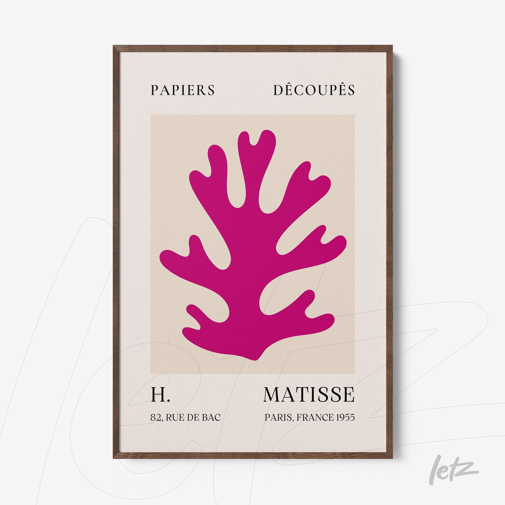 decorative wall art featuring a pink coral cutout on a neutral background with dark wooden frame